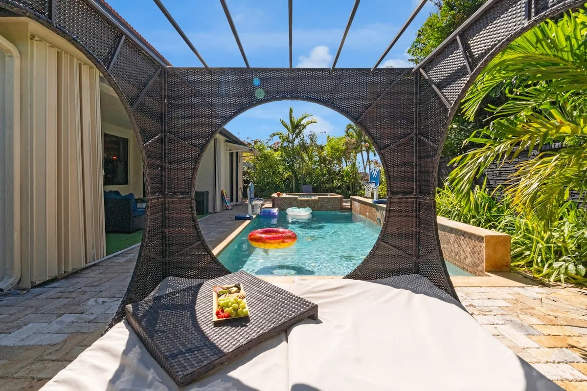 Piscina con cama colgante y vegetación alrededor